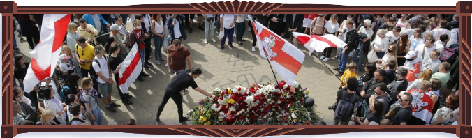 Photograph of the civic funeral of protester Alexander Taraikovsky. Hundreds of mourners wave old Belarusian white and red flags, and throw flowers onto the open casket. AP Photo/Dmitri Lovetsky.